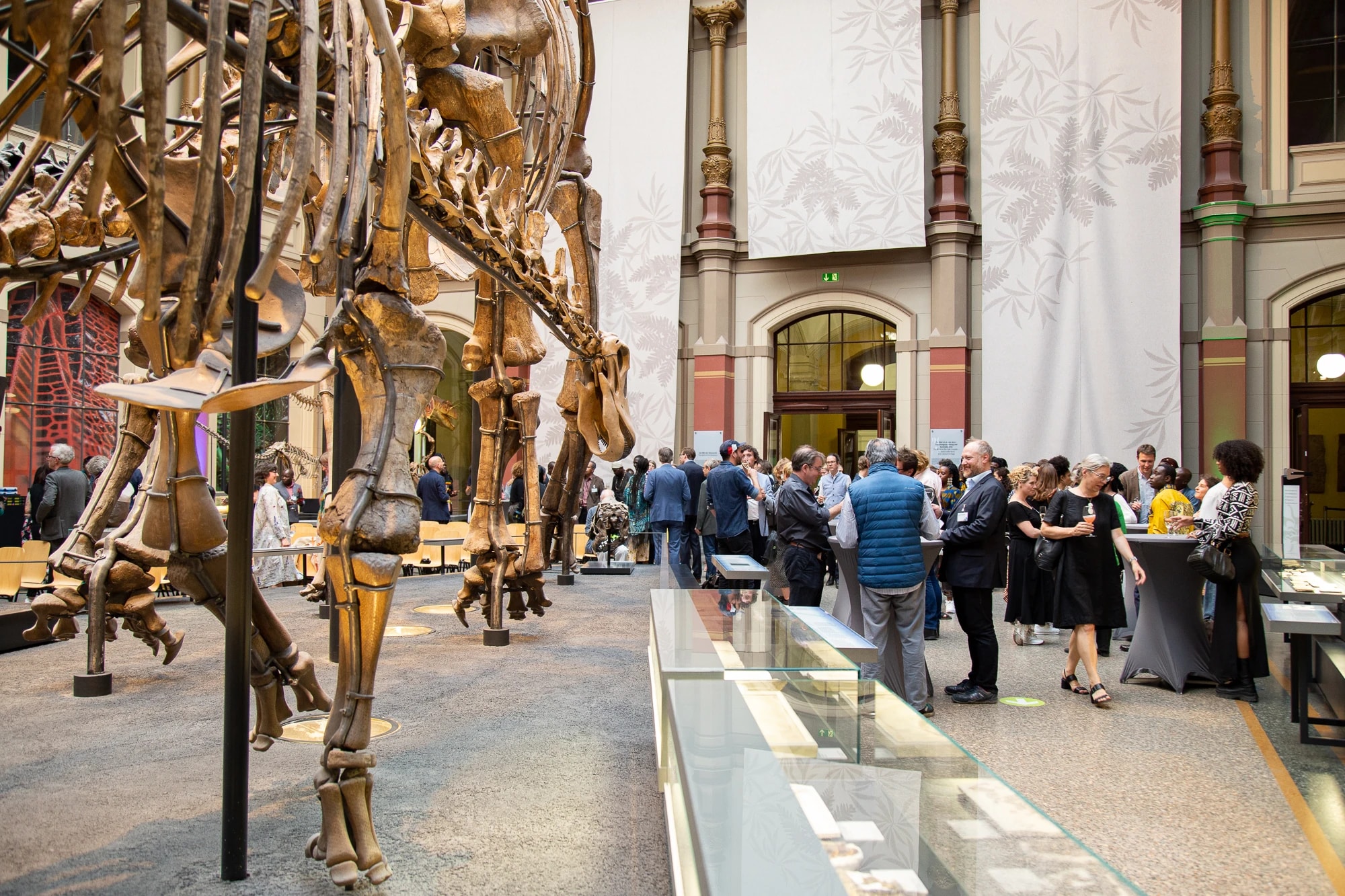People standing together at a public event in the dinosaur hall of the Natural History Museum in Berlin