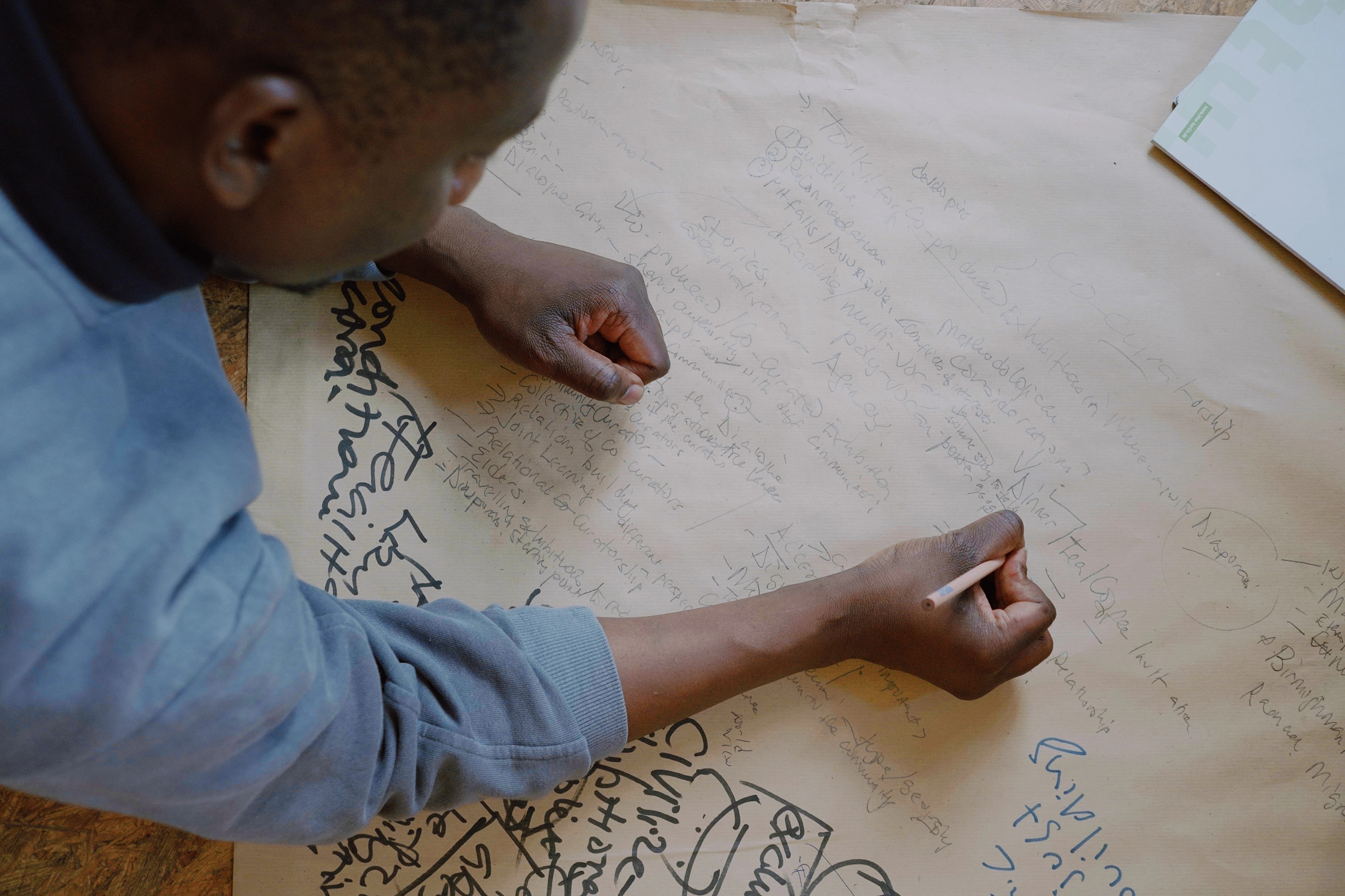 by Muhamad Salah a person writing on scrap paper